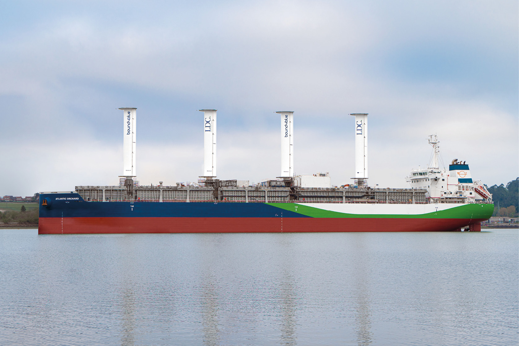 A large cargo ship sailing on the sea with large, innovative rigid wind sails installed on its deck to assist with propulsion.