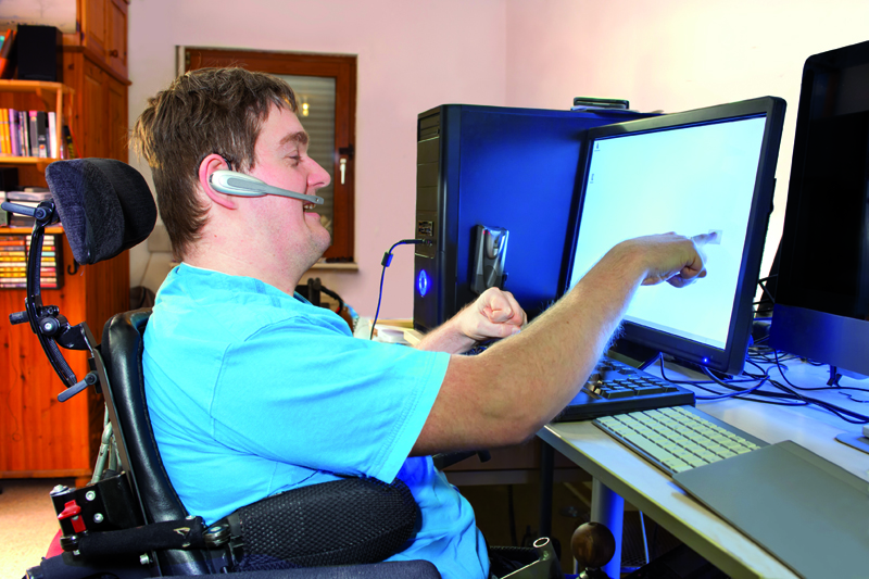 Niepełnosprawny mężczyzna pracuje przy komputerze