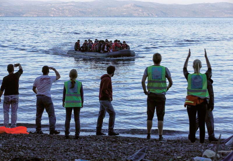 Uchodźcy w pontonie dopływają do plaży na greckiej wyspie