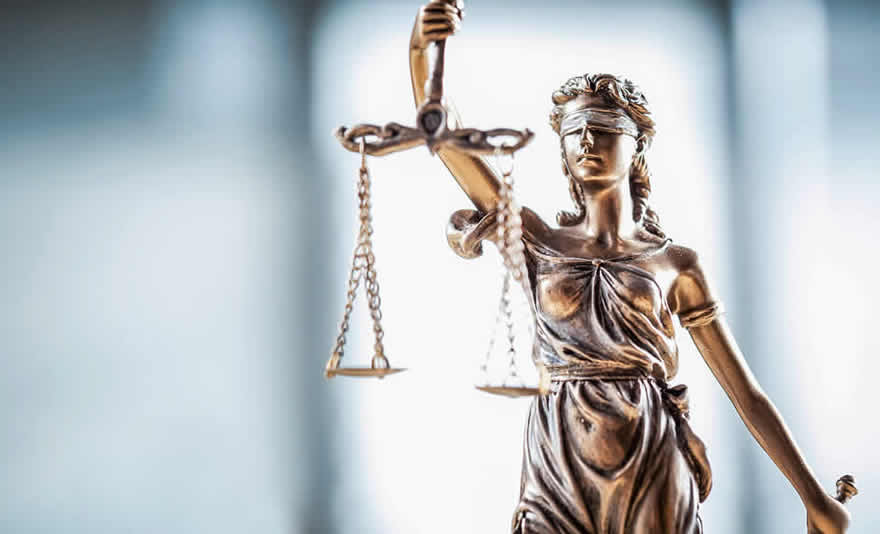 Image: A blindfolded Lady Justice statue holding up scales in one hand and a sword in the other. © Fotolia