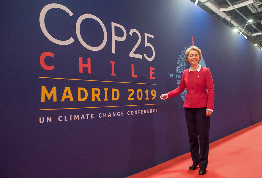Ursula von der Leyen voor een muur met het logo van de klimaatconferentie van de Verenigde Naties (COP25)