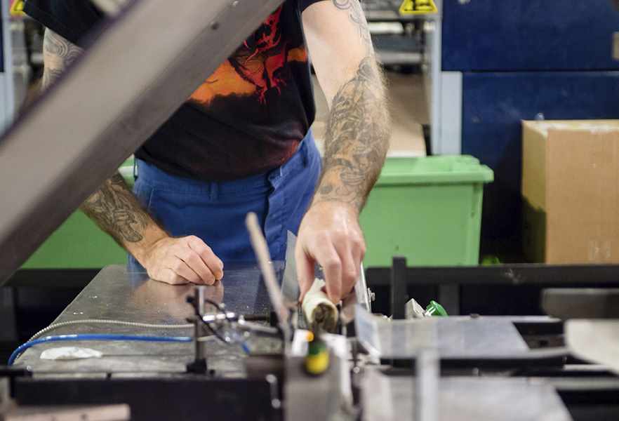 Een fabrieksarbeider bedient een machine