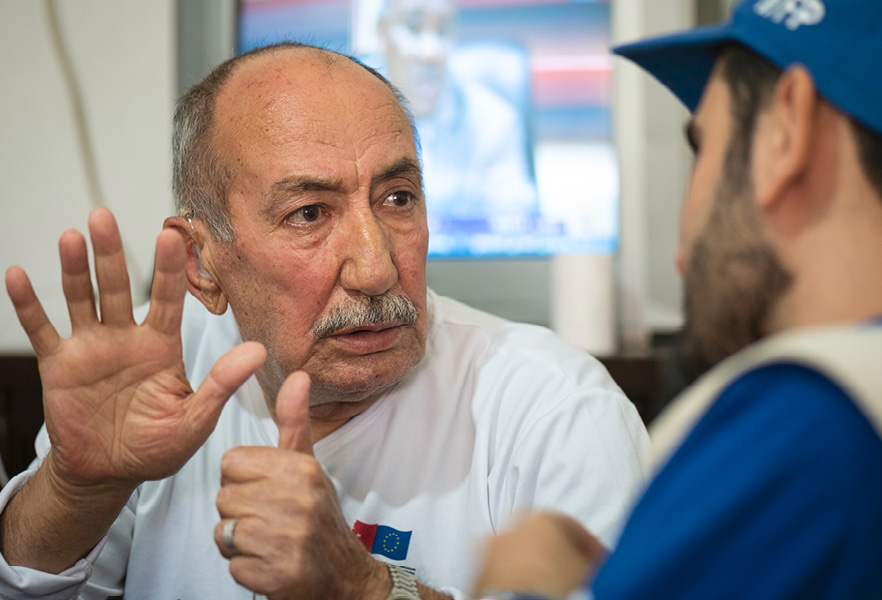 Starší muž pri rozhovore s humanitárnym pracovníkom