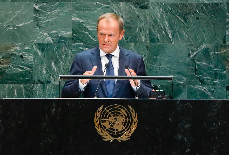 Donald Tusk houdt een toespraak vanachter een katheder