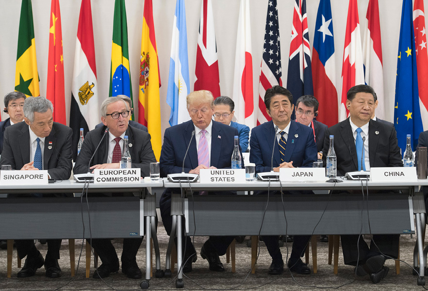 Lee Hsien Loong, Jean-Claude Juncker, Donald Trump, Shinzō Abe en Xi Jinping zitten naast elkaar achter een tafel