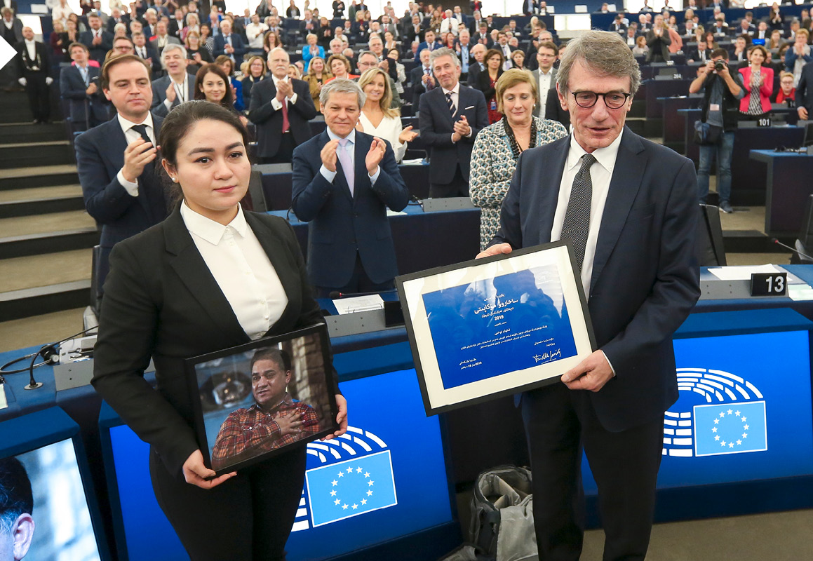Jewher Ilham draagt een foto van haar vader terwijl David Sassoli haar de Sacharovprijs voor haar vader overhandigt