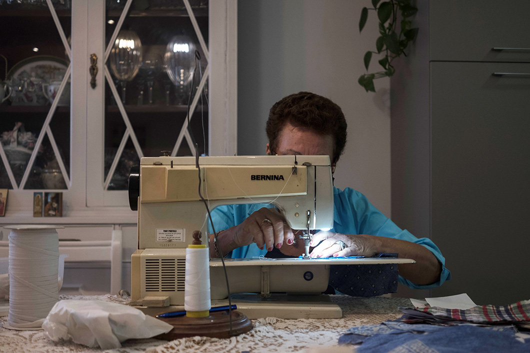 A volunteer working a sewing machine in her home.