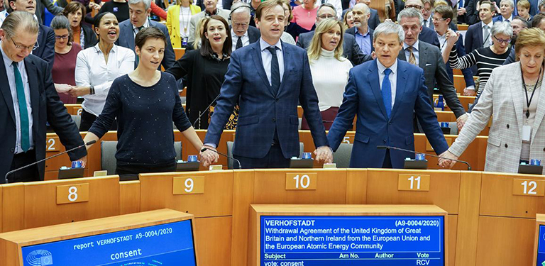 Members of the European Parliament standing and holding hands in the European Parliament.