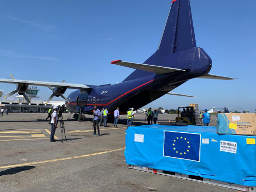 A plane being loaded, with a pallet branded with the EU flag standing in front of it.