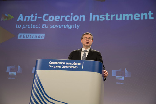 Valdis Dombrovskis stojící na pódiu během projevu.