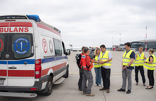Janezas Lenarčičius kalbasi su greitosios pagalbos darbuotojais šalia greitosios pagalbos automobilio.