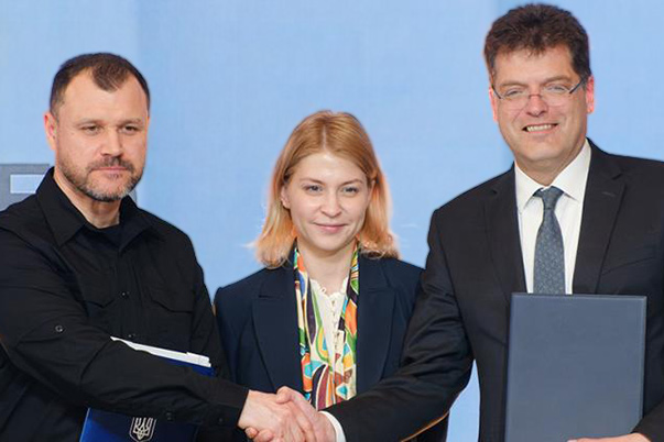 Ihor Klymenko und Janez Lenarčič reichen sich die Hand. Olha Stefanischyna steht zwischen beiden.