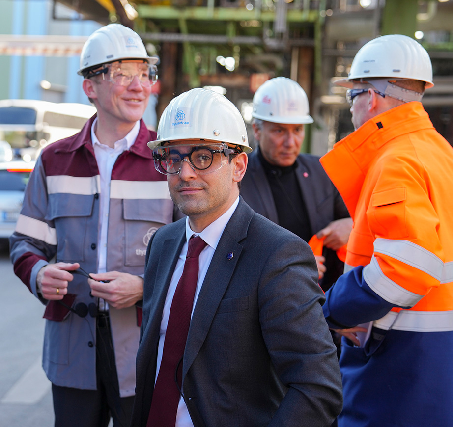 Stéphane Séjourné v popredí s ochrannou helmou. V pozadí sú štyri ďalšie osoby, ktoré už majú na sebe reflexné vesty, ochranné helmy a chrániče zraku alebo si tieto pomôcky práve preberajú.