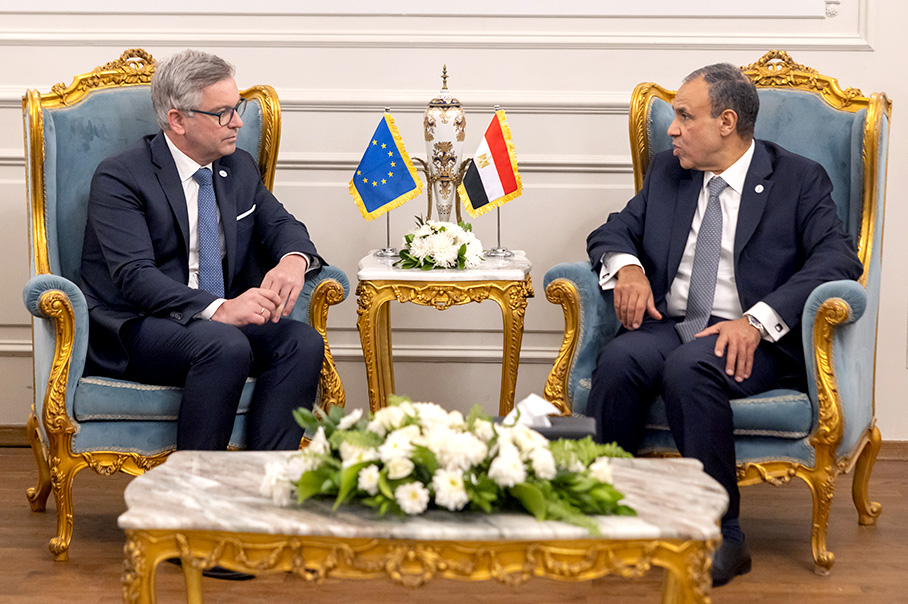 Magnus Brunner, sitting opposite Badr Abdelatty, having a conversation. There are small European and Egyptian flags on the table between them.
