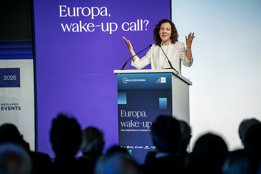 Roxana Mînzatu står i en talarstol och håller ett anförande. På talarstolen och på en stor lila skylt bakom henne visas orden ”Europa, wake-up call?” (En väckarklocka för Europa?).