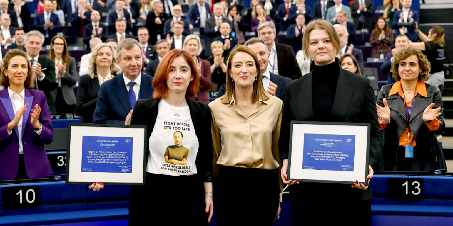 Η κυρία Ρομπέρτα Μέτσολα πλαισιώνεται από δύο γυναίκες, την κυρία Γιάνα Πάτσομπουτ και την κυρία Ίρμα Ντιμιτράτζε. Καθεμιά τους κρατά από ένα καδραρισμένο μπλε πιστοποιητικό του Βραβείου Ζαχάρωφ. Πίσω τους στέκονται όρθια χειροκροτώντας τα μέλη του Ευρωπαϊκού Κοινοβουλίου.