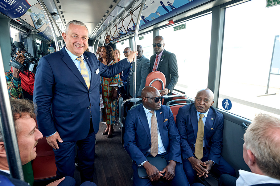 Йозеф Сикела стои в автобус и се усмихва пред камерата.