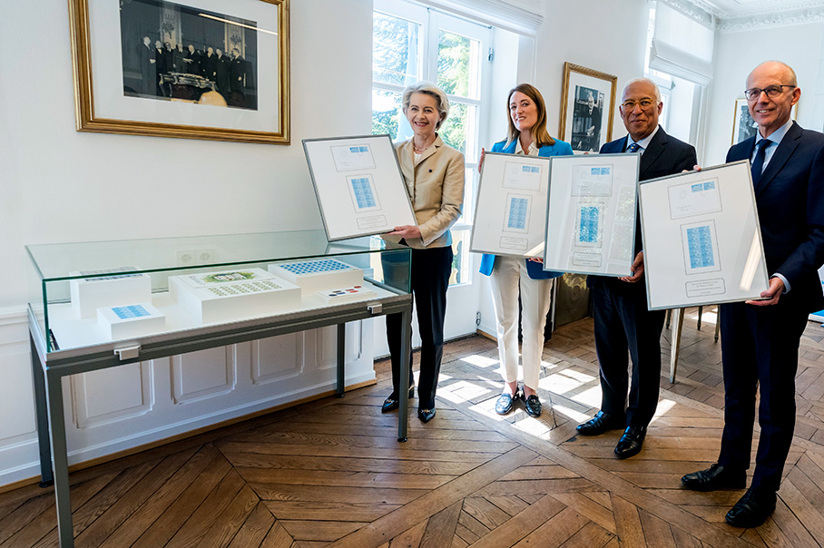 Урсула фон дер Лайен, Роберта Мецола, Антонио Коща и Люк Фриден заедно държат един и същ документ в рамка.