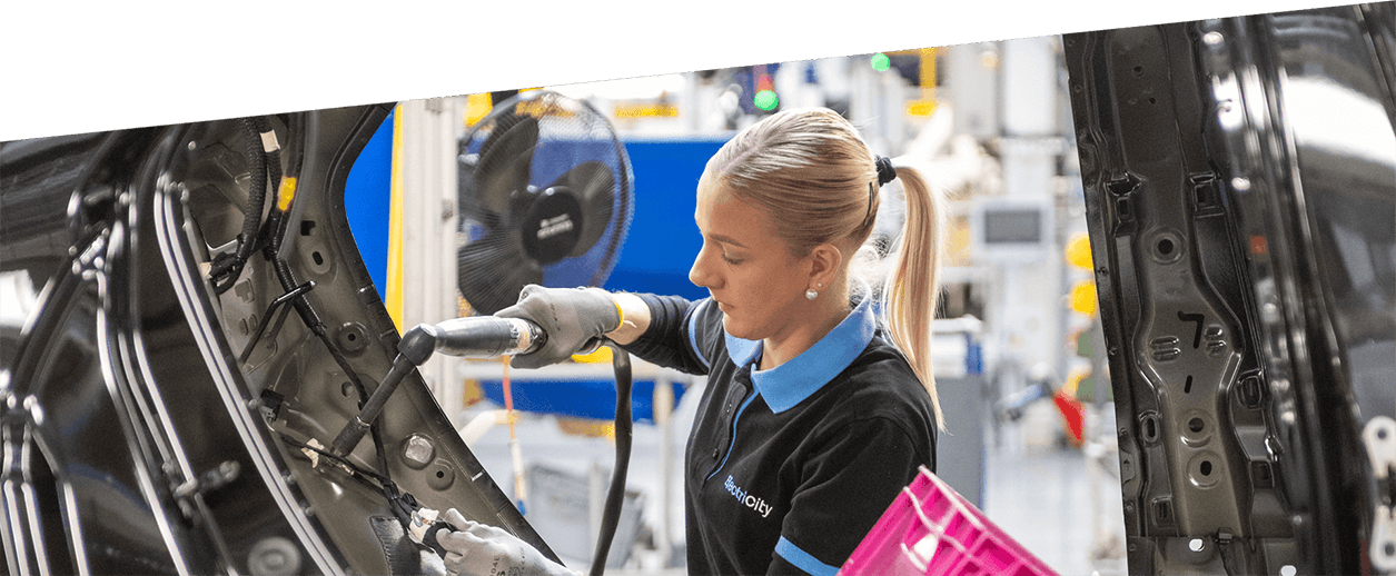 Zamestnankyňa pracujúca na montážnej linke v automobilovom závode.