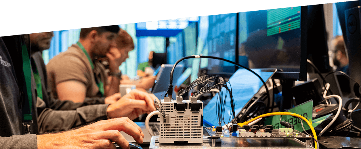 A group of people sitting in front of screens in an open-plan office environment.