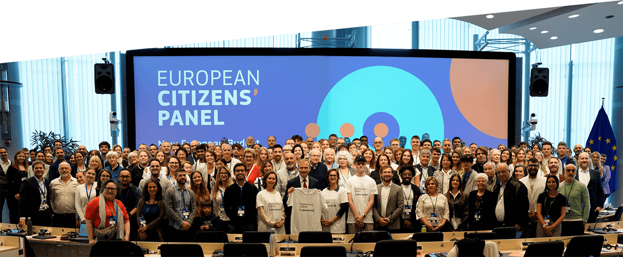 Конферентна зала, пълна с участници, застанали пред екран, на който са изписани думите „Европейски граждански панел“.