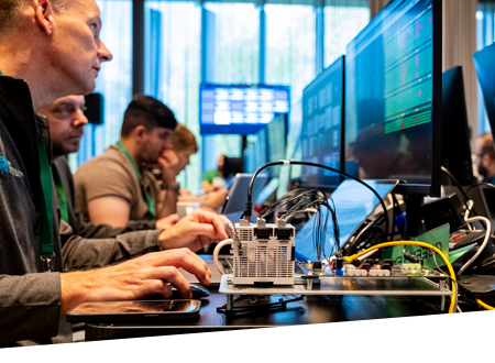 Un grup de persoane așezate în fața unor ecrane într-un spațiu de birouri deschis.