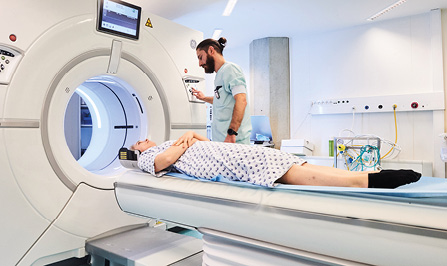 Un profesional sanitario realiza una tomografía por resonancia magnética a un paciente.