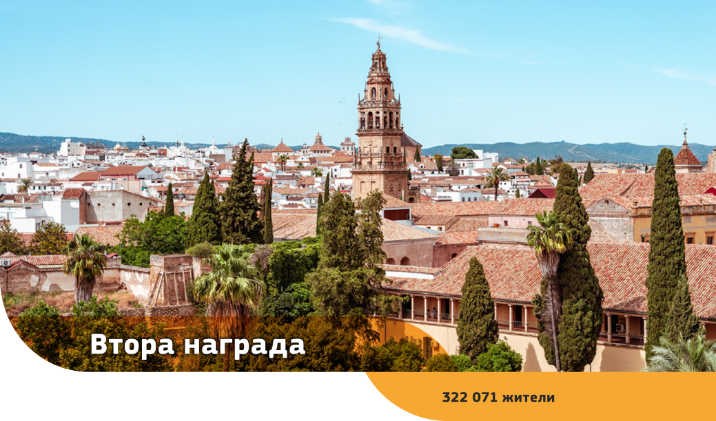 Дървета и керемидени покриви на джамията-катедрала в Кордоба със сгради и хълмове на заден план